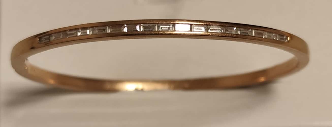 UNA PULSERA REALIZADA EN ORO KTE 18 CON DIAMANTES TALLA BAGUETTE QTE 0,90 TOTAL APROX. (DEFECTOS). PESO APROX. 15,5 GRS. MEDIDA 57 MM X 43 MM. DETERIOROS EN GRAL.