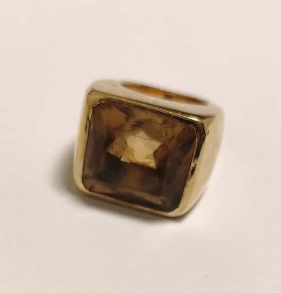 UN ANILLO REALIZADO EN ORO CON CITRINA, ABOLLADURA EN LA BASE. (INF LAB 86395) PESO APROX. 23,7 GRS. MEDIDA 16. DETERIOROS EN GRAL.