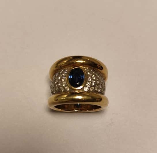 UN ANILLO REALIZADO EN ORO Y ORO BLANCO KTE 18 CON BRILLANTES QTE0,80 TOTAL APROX. Y ZAFIRO CENTRAL. (INF LAB 86364). MEDIDA 15. PESO APROX. 18,2 GRS.