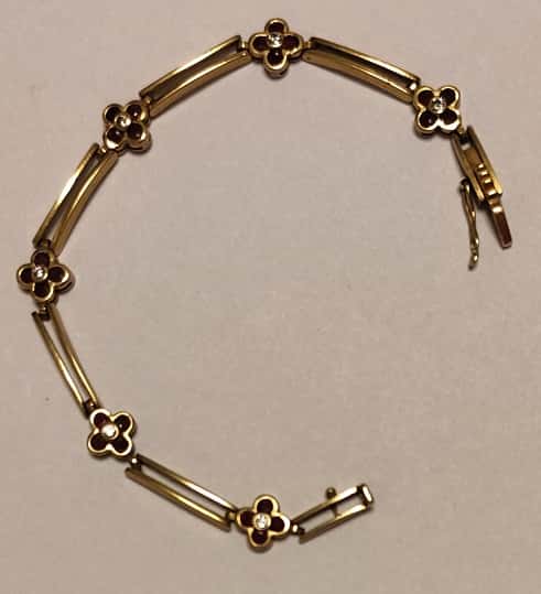 UNA PULSERA ARTICULADA REALIZADA EN ORO KTE 18 CON BRILLANTES Y RUBIES. CIERRE FLOJO CON SEGURO. PESO APROX. 12 GRS. (LAB INF 86531). MEDIDA 17,5 CM DETERIOROS EN GRAL.