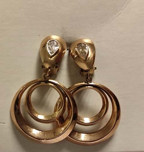 UN PAR DE AROS CLIP CON PASANTE REALIZADOS EN ORO KTE 18 CON ZIRCONIAS CUBICAS. (INF LAB 86528). PESO TOTAL APROX. 7,2 GRS. ALTO 42 MM. DETERIOROS EN GRAL.
