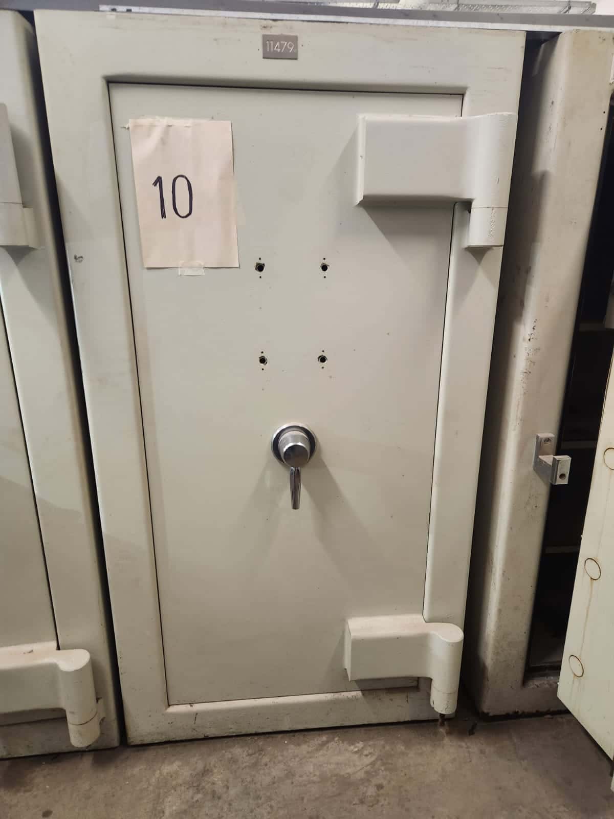 UN COFRE DE SEGURIDAD, USADO, SIN MARCA VISIBLE; IDENTIFICADO CON NÚMERO DE INVENTARIO 11479. CONSTRUIDO EN HORMIGÓN Y CHAPA DE ACERO, DIMENSIONES EXTERIORES APROXIMADAS: 1,85 M. DE ALTO POR 1,10 M. DE ANCHO Y 1.05 M. DE PROFUNDIDAD. PESO APROX. 3500 KG. POSEE UNA PUERTA FRONTAL CON BISAGRAS EXTERNAS REFORZADAS, SISTEMA DE CIERRE MECÁNICO CENTRAL TIPO VOLANTE, (SIN CERRADURAS DE COMBINACIÓN NUMÉRICA). EN SU INTERIOR PRESENTA DOS COFRES SECUNDARIOS INDEPENDIENTES, (SIN CERRADURAS MECÁNICAS NI COMBINACIÓN NUMÉRICA) Y ESTANTES INFERIORES. CON DETERIOROS GENERALES, AVERÍAS, DESARMES E INCOMPLETO. SE VENDE EN EL ESTADO QUE SE ENCUENTRA Y EXHIBE.