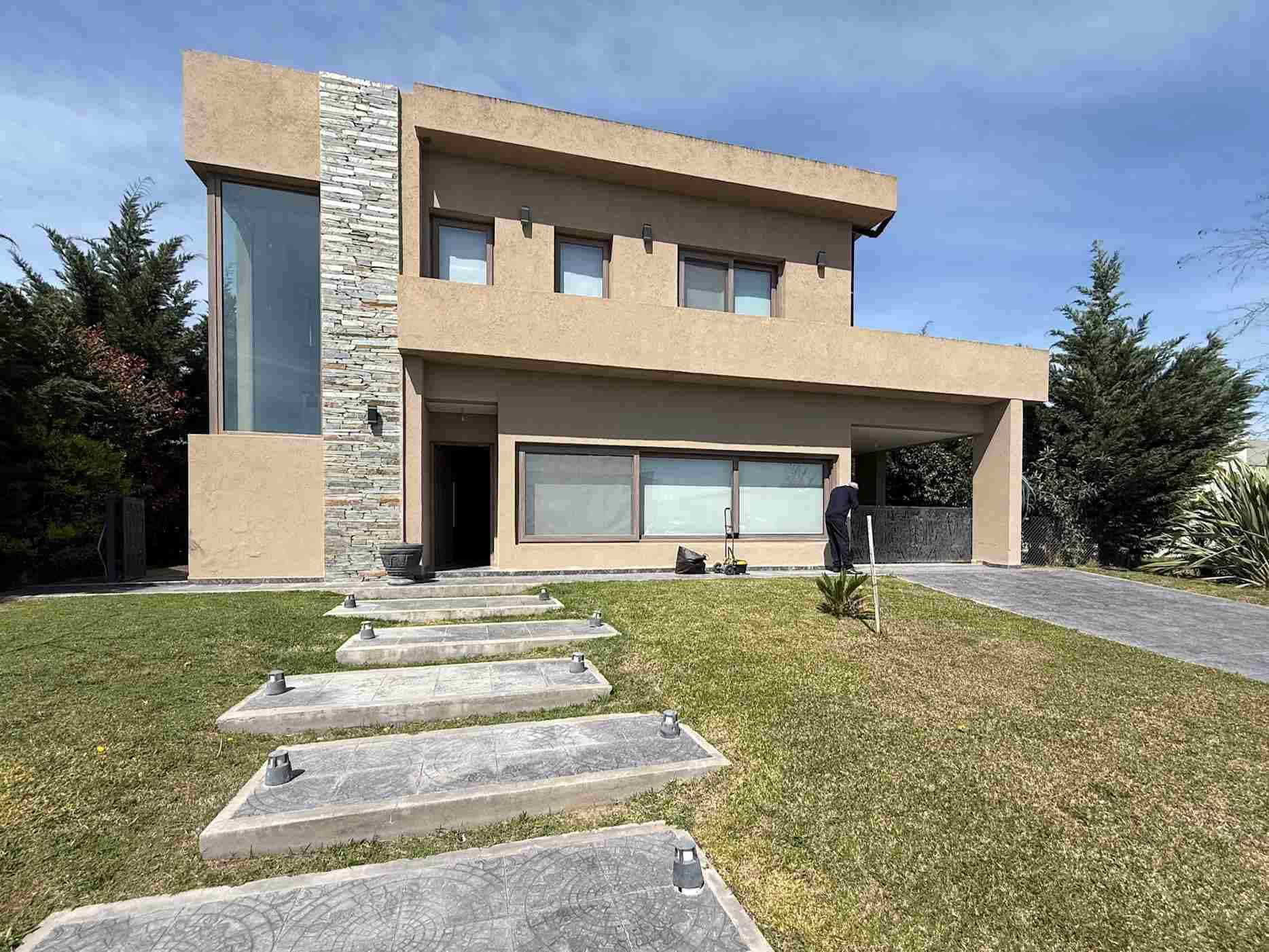 DERECHOS FIDUCIARIOS SOBRE LA U.F. 381, BARRIO HORIZONTES AL SUR. RUTA 16, KM 1,5, entre AV. NESTOR KIRCHNER Y R.P. 58 GUERNICA, PROVINCIA DE BS. AS. Barrio cerrado de viviendas con amenities deportivos, caminos pavimentados y 2 espejos de agua internos. Portal de ingreso peatonal y vehicular para propietarios y visitas diferenciados y guardia de seguridad permanente. La UF se ubica en un lote interno distante unos 1.000 m del acceso al barrio. De orientación NO-SE con 20 m de frente por 35 m de fondo. Contiene una construcción de vivienda de 2 plantas totalizando unos 250 m2 cubiertos de superficie homogeneizada. De tipología moderna. con techos planos aberturas amplias con cortinas roller y revestimiento de frente tipo Tarquini monocromático. La planta baja se organiza con un acceso peatonal y el acceso vehicular para 2 vehículos en profundidad. Se ingresa a un living de amplias dimensiones el cual se vincula con una cocina abierta hacia el lateral izquierdo, un espacio quincho cerrado hacia el fondo con un toilette y la cochera doble a la derecha. Posteriormente al quincho se desarrolla un espacio semicubierto con techo traslúcido que cuenta con un espacio parrilla a la derecha. y se abre al fondo del terreno en donde se encuentra la piscina. Próximo a la cocina se accede a la habitación principal a través de un pasillo vestidor, que vincula también al baño en suite hacia la izquierda. equipado con una bañera con hidromasaje doble, terminando en el dormitorio que ilumina al fondo de la vivienda. Del acceso peatonal a la vivienda se ubica a la izquierda un toilette de servicio y la escalera que vincula con la planta alta. En planta alta se arriba a un espacio distribuidor desde el cual se distribuyen 3 dormitorios, un baño completo y hacia el contrafrente un playroom con acceso a una terraza, desde la cual por medio de una escalera externa se accede al espacio fondo/piscina de planta baja. SUPERFICIE: UF 381 Parcela: 700 M2. Cubierta total: 277,95 M2. NOMENCLATURA CATASTRAL: Circunscripción: VII, Sección: Rural, Parcela: 403 I, Polígono: 00-30