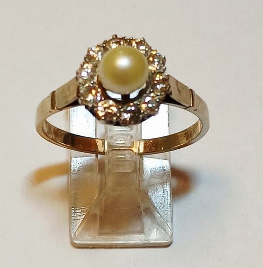 UN ANILLO REALIZADO EN ORO Y ORO BLANCO KTE 18 CON PERLA DE CULTIVO CENTRAL Y BRILLANTES QTE 0.35 TOTAL APROX. CIRCUNDANTES, PESO TOTAL APROX. 3.6 GRS. MEDIDA 23