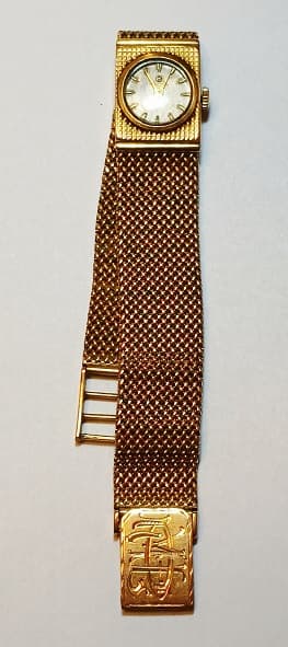 UNA PULSERA ARTICULADA CON RELOJITO DE ORO KTE 18 CUADRANTE DICE ELECTION, NO FUNCIONA. PESO TOTAL APROX. 45.3 GRS.