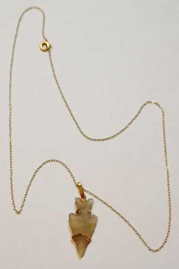 UN COLLAR CON COLGANTE DE ORO KTE 18 Y PIEDRA HIALINA, REPRESENTANDO PUNTA DE FLECHA. PESO TOTAL APROX. 3 GRS.