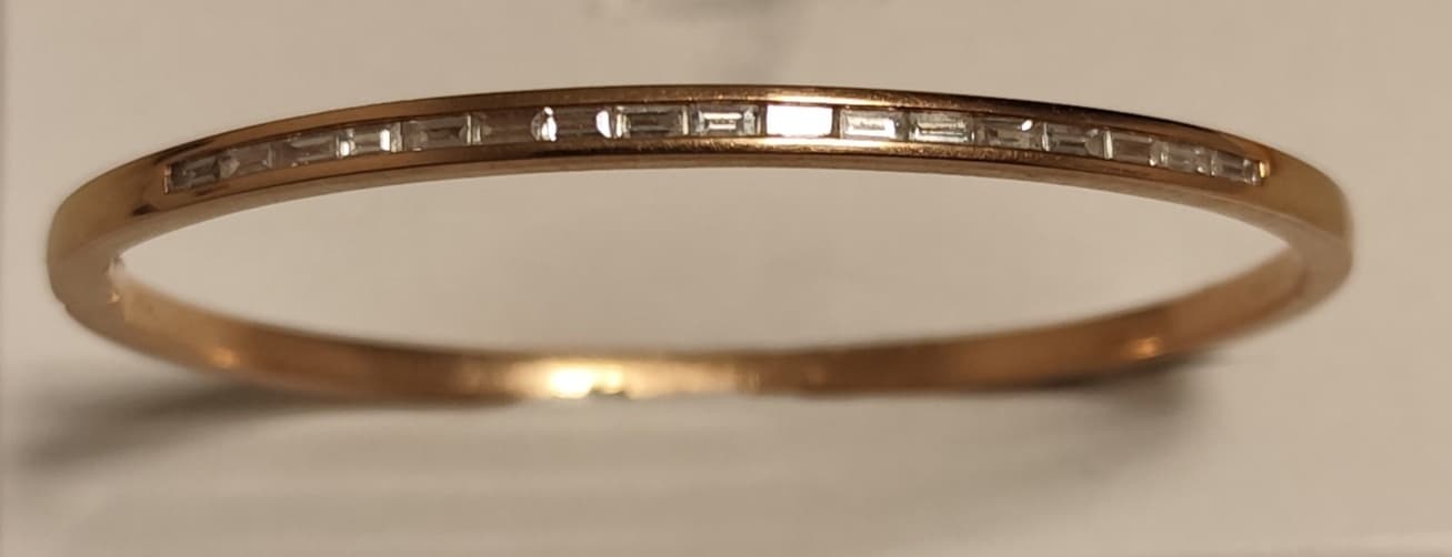 UNA PULSERA REALIZADA EN ORO KTE 18 CON DIAMANTES TALLA BAGUETTE QTE 0,90 TOTAL APROX. (DEFECTOS). PESO APROX. 15,5 GRS. MEDIDA 57 MM X 43 MM. DETERIOROS EN GRAL.
