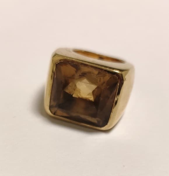 UN ANILLO REALIZADO EN ORO CON CITRINA, ABOLLADURA EN LA BASE. (INF LAB 86395) PESO APROX. 23,7 GRS. MEDIDA 16. DETERIOROS EN GRAL.