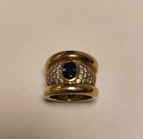 UN ANILLO REALIZADO EN ORO Y ORO BLANCO KTE 18 CON BRILLANTES QTE0,80 TOTAL APROX. Y ZAFIRO CENTRAL. (INF LAB 86364). MEDIDA 15. PESO APROX. 18,2 GRS.