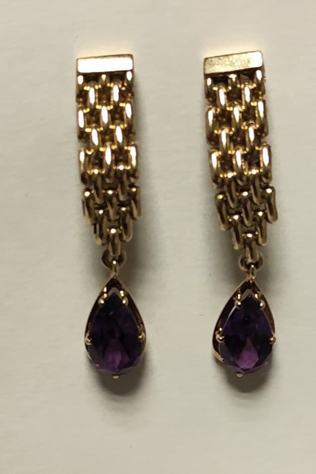UN PAR DE AROS CLIP CON PASANTE DE ORO KTE 18 CON ZAFIROS SINTETICOS VIOLACEOS. (LAB INF 86526) PESO TOTAL APROX. 17,4 GRS. LARGO 5 CM. DETERIOROS EN GRAL.