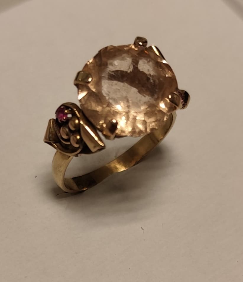 UN ANILLO REALIZADO EN ORO KTE 18 CON VIDRIO CENTRAL (DESGASTES, ROTURAS) Y RUBIES SINTETICOS . (LAB INF 86527). PESO APROX. 5,2 GRS MEDIDA 22