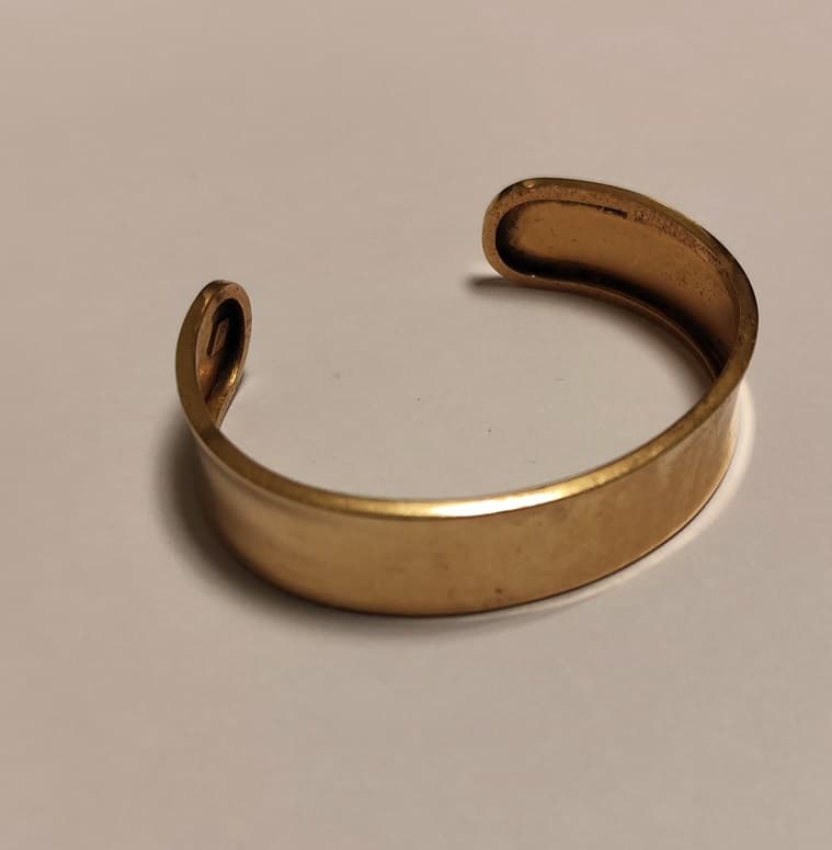 UNA PULSERA RIGIDA ABIERTA REALIZADA EN ORO KTE 18. MEDIDA ANCHO 58 MM. PESO APROX. 19,5 GRS.DETERIOROS EN GRAL.