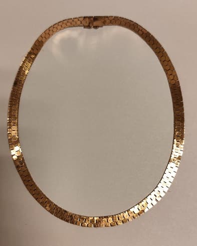 UNA GARGANTILLA DE ESLABON PLANO REALIZADA EN ORO KTE 18.CIERRE CON SEGURO DE ORO. PESO APROX. 31,6 GRS. DETERIOROS EN GRAL. MEDIDA 42,5 CM.