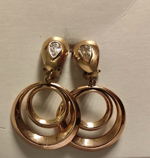 UN PAR DE AROS CLIP CON PASANTE REALIZADOS EN ORO KTE 18 CON ZIRCONIAS CUBICAS. (INF LAB 86528). PESO TOTAL APROX. 7,2 GRS. ALTO 42 MM. DETERIOROS EN GRAL.
