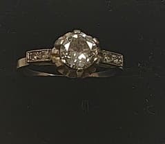UN ANILLO DE PLATINO CON BRILLANTE CENTRAL QTE. 0.70 APROX. DEFECTOS. Y BRILLANTES LATERALES QTE. 0.05 TOTAL APROX. DEFECTOS. PESO 3.3 GRS. TOTAL APROX. MEDIDA 15.5 APROX.