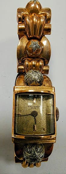 UNA PULSERA ARTICULADA CON RELOJITO DE ORO CUADRANTE DICE UNIVERSAL NO FUNCIONA. ADORNOS DE PLATINO CON BRILLANTES QTE. 0.25 TOTAL ARPOX. DEFECTOS. PESO 43.5 GRS. TOTAL APROX.