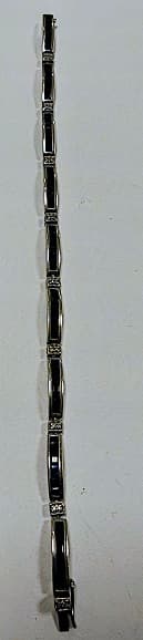 UNA PULSERA ARTICULADA RODINADA, DE ORO BAJO CON BRILLANTES. QTE. 0.08 TOTAL APROX. DEFECTOS Y ZAFIROS SINTETICOS. PESO 11.7 GRS. TOTAL APROX. LENGUETA DE METAL.