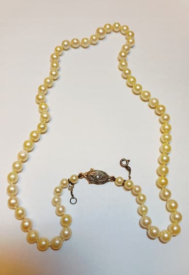 UN COLLAR DE PERLAS DE CULTIVO CON BROCHE DE ORO Y PLATINO CON BRILLANTE (DEF) QTE 0.01 APROX. CON CADENA DE SEGURIDAD DE PLATA. MEDIDA 18.5 CM