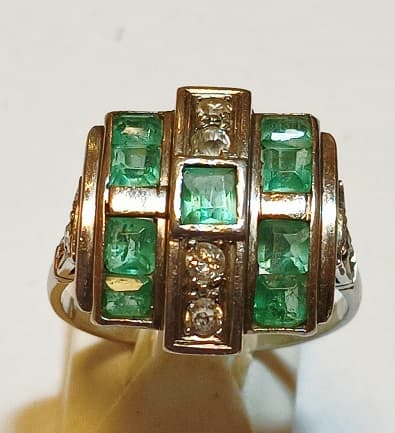 UN ANILLO REALIZADO EN PLATINO CON BRILLANTES (DEF) QTE 0.12 TOTAL APROX., DIAMANTES Y BERILOS VERDES. ROTURA EN DIAMETRO DEL ANILLO. PESO 5.6 GRS APROX. MEDIDA 14