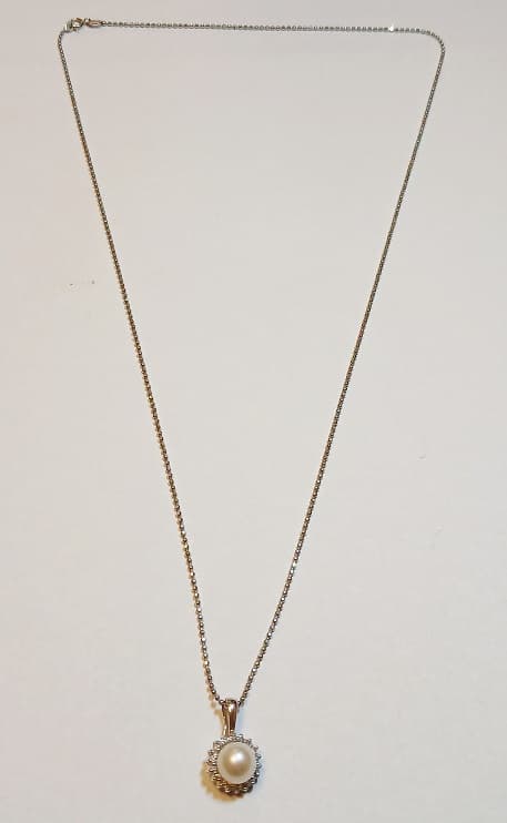 UN CONJUNTO COMPUESTO POR UN COLLAR Y COLGANTE REALIZADO EN ORO BLANCO BAJO KTE 14 CON PERLA DE CULTIVO CENTRAL Y BRILLANTES CIRCUNDANTES QTE 0.09 TOTAL APROX. PESO TOTAL APROX. 3.9 GRS.
