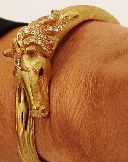 UNA PULSERA RIGIDA REALIZADA EN ORO KTE 18 CON BRILLANTES QTE 0.85 TOTAL APROX. Y PIEDRAS AZULES SIN POSIBILIDAD DE DETERMINAR PESO 36.5 GRS.