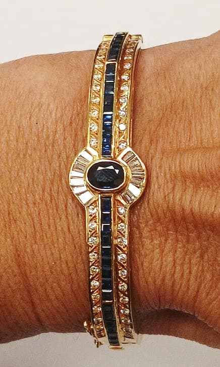 UNA PULSERA REALIZADA EN ORO KTE 18 CON BRILLANTES QTE 0.44 TOTAL APROX. DIAMANTES TALLA BAGUETTE Y KEYSTONE Y PIEDRAS AZULES SIN POSIBILIDAD DE DETERMINAR PESO 20.7 GRS. APROX.